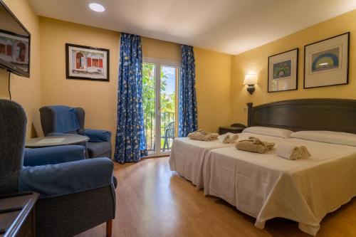 a hotel room with two beds and a window at Hotel Balneario de Chiclana in Chiclana de la Frontera