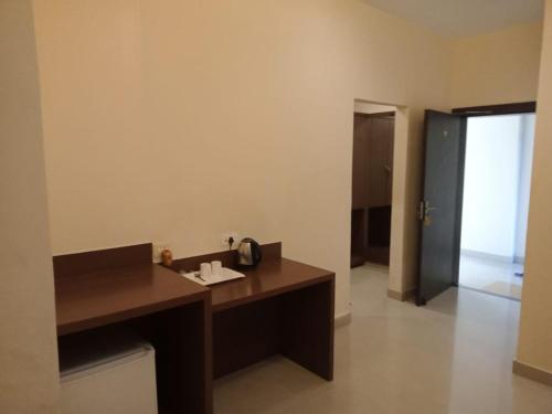 a bathroom with a wooden desk and a hallway at The Contour Hotel in Guwahati