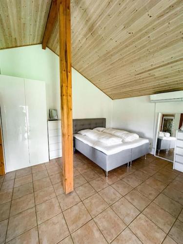 1 dormitorio con cama y techo de madera en Hyggeligt anneks på Thurø, tæt på vandet., en Svendborg