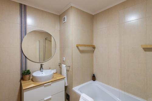 a bathroom with a sink and a tub and a mirror at Belavista Oceanside in Ribeira Grande
