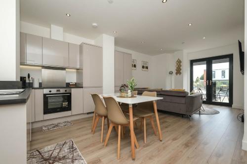 a kitchen and living room with a table and chairs at Brand New 2 bedroom apartment Centre of Solihull in Solihull