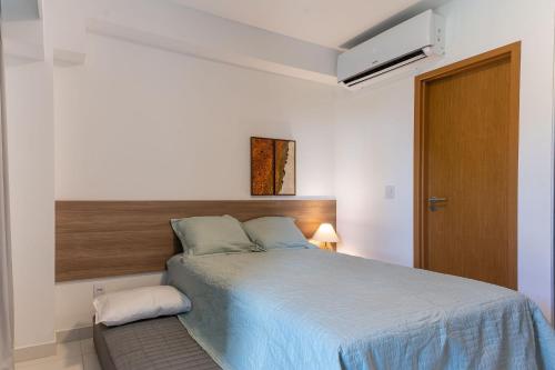 a bedroom with a bed with a wooden headboard at Praia de Muro Alto Mana Beach 003 C in Porto De Galinhas