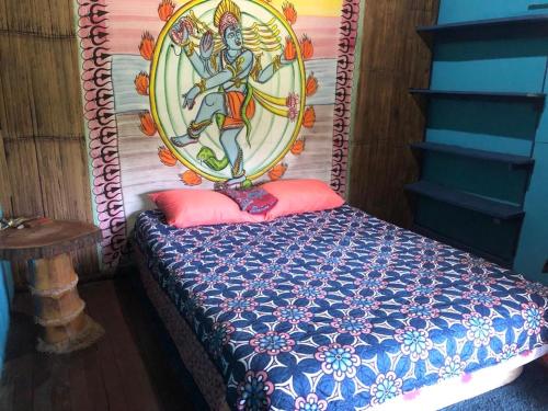 a bedroom with a bed with a painting on it at Finca Bambú Del Valle in Santa Clara