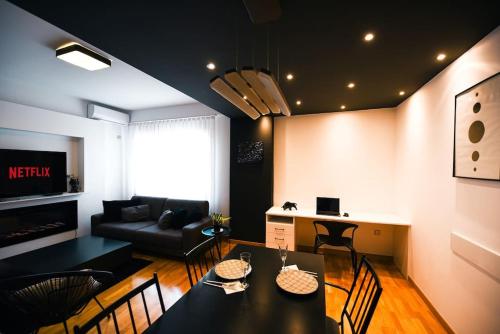 a living room with a black table and chairs at Monochromatic Apartment in Prishtinë