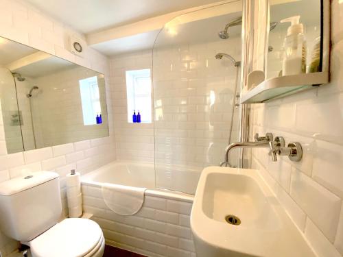 ロンドンにあるThe Barnsbury, London Apartment with WIFIの白いバスルーム(バスタブ、トイレ、シンク付)