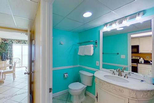 a bathroom with a sink and a toilet and a mirror at Camelot by the Sea 1804 in Myrtle Beach