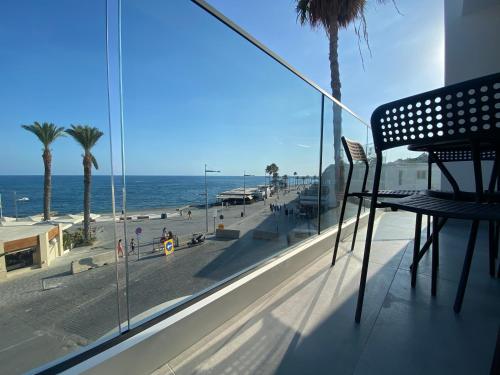 a balcony with a bench looking out at the beach at Sea La Vie #2 - Luxury Seaview apartment in Paphos City