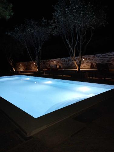 a swimming pool lit up at night at Villa Art Natalie in Kithnos