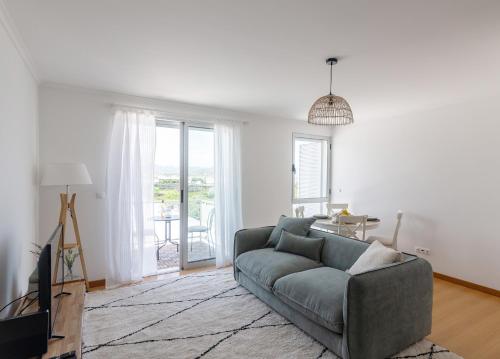 a living room with a couch and a tv at Belavista Oceanside in Ribeira Grande