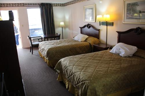 um quarto de hotel com duas camas e uma janela em American Inn of Selma em Selma