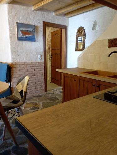 a kitchen with a counter and a table and chairs at Villa Art Natalie in Kithnos