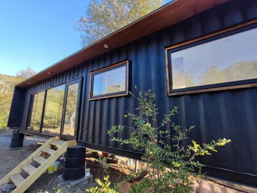 a black house with windows on the side of it at Hermosa vista y casa acogedora in Pinto