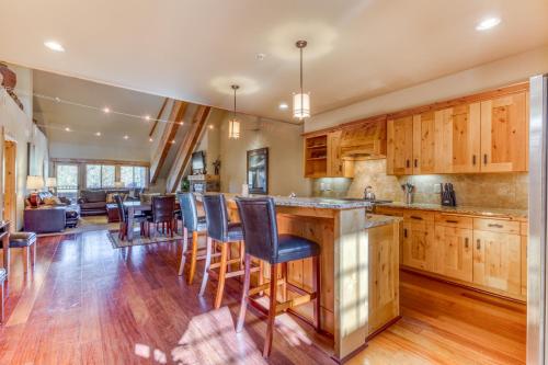 a kitchen with wooden cabinets and a bar with bar stools at #402 Grand Lodge South Penthouse in Government Camp