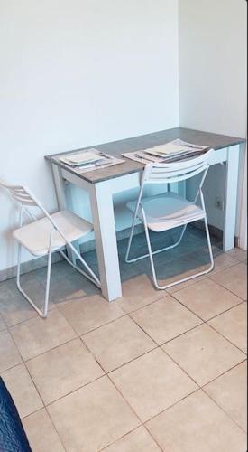 - un bureau avec deux chaises et une table avec des papiers dans l'établissement Charmant studio de 23m2, à Avignon