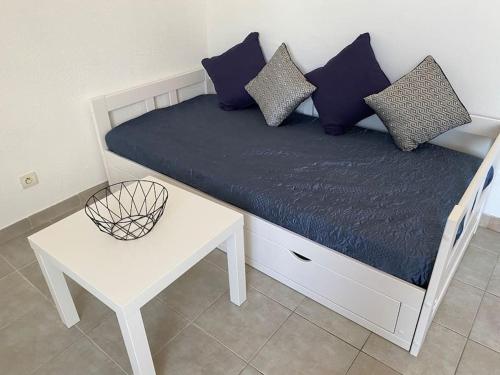- un lit avec des oreillers violets et une table blanche dans l'établissement Charmant studio de 23m2, à Avignon