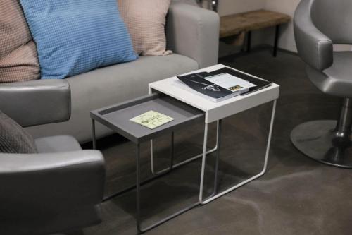 two tables in a living room with a couch at Wake Up Wellness Hostel in Brno