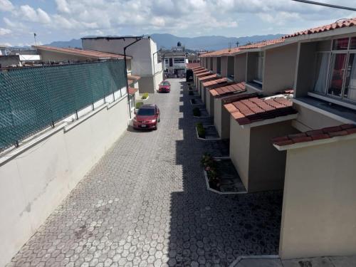 a car driving down a street between buildings at Hotel y Bungalows Santa Ana in Quetzaltenango