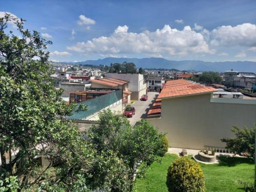 vistas a una ciudad con edificios y árboles en Hotel y Bungalows Santa Ana en Quetzaltenango