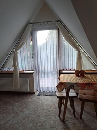 ザコパネにあるWilla Małgorzata pod skoczniąの窓とテーブル付きのテントが備わる屋根裏部屋