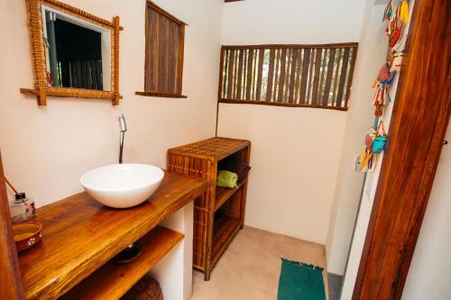 uma casa de banho com um lavatório branco num balcão de madeira em Cabana na árvore na Bahia! Para viver uma experiência de hospedagem pertinho da praia em Maraú