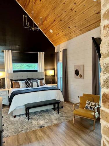 a bedroom with a large bed and a chair at Double Arrow Cabin in Broken Bow