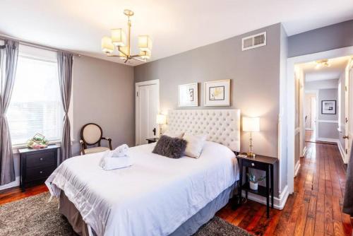 a bedroom with a large white bed and a chandelier at OTR Penthouse Walk Everywhere FREE Parking in Cincinnati