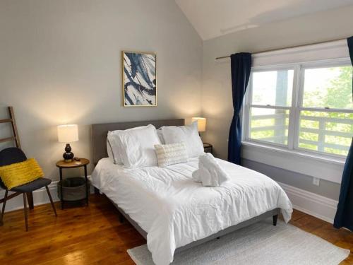 Schlafzimmer mit einem Bett mit weißer Bettwäsche und einem Fenster in der Unterkunft Explore Downtown and Mount Adams with River Views in Cincinnati
