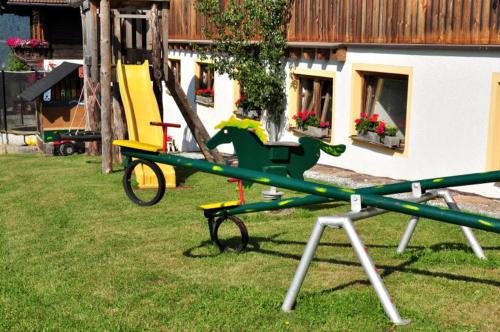 um parque infantil com um avião de brinquedo na relva em Pferdehof Oberegg em Werfenweng