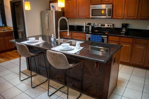 a kitchen with a kitchen island with chairs and a sink at Great Parkside Apt w Private Patio and Sun Deck in Cincinnati