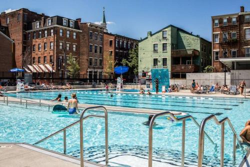 a large swimming pool with people in the water at Great Parkside Apt w Private Patio and Sun Deck in Cincinnati