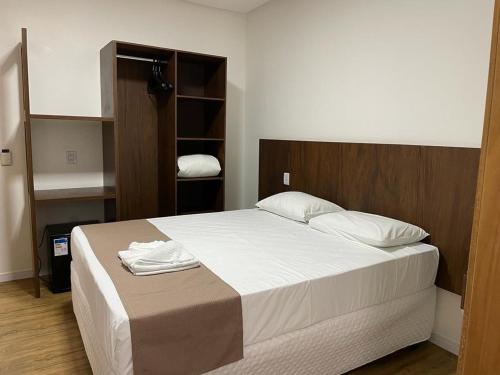 a bedroom with a large bed with white sheets at Éden Hotel in Rio Verde