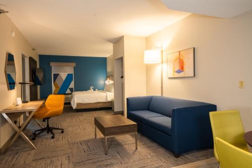 Pokój hotelowy z niebieską kanapą i łóżkiem w obiekcie Holiday Inn Express Hotel & Suites Tampa-Oldsmar, an IHG Hotel w mieście Oldsmar