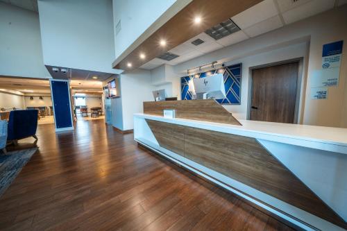 an office lobby with a reception counter and wooden floors at Holiday Inn Express Hotel & Suites Tampa-Oldsmar by IHG in Oldsmar