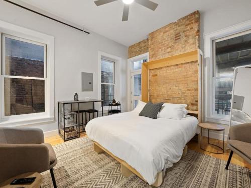 um quarto com uma cama grande e uma parede de tijolos em Over the Rhine Luxury MicroSuite On Findlay Market em Cincinnati