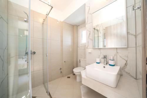 ein Bad mit einem WC, einem Waschbecken und einer Dusche in der Unterkunft Villa Roz by Villa Plus in Plateies