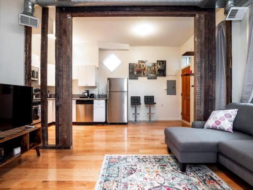 a living room with a couch and a kitchen at Cozy OTR Home with Private Roof Deck in Cincinnati