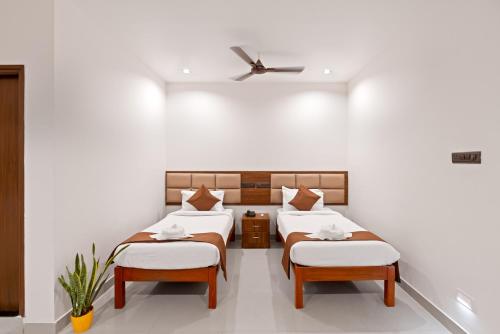 a bedroom with two beds and a ceiling fan at The Elite Hotel in Hyderabad