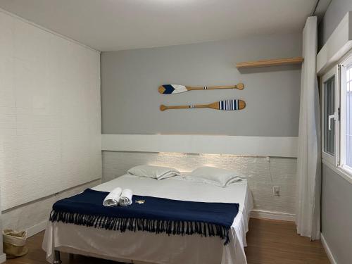 a bedroom with a bed with two baseball bats on the wall at Casa de praia em Floripa - conforto e aconchego a 400m da praia in Florianópolis