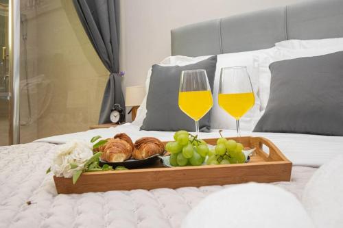 a tray of food and two glasses of wine on a bed at Active holiday in nature on agritourism! Make wine or olive oil!!! in Posedarje