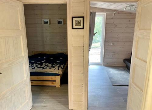 a bedroom with a bed in the middle of a room at Obuoliu Sala COZY HOUSE on the Apple Island in Gaylyunay