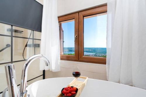a glass of wine and a bowl of fruit on a bath tub at Active holiday in nature on agritourism! Make wine or olive oil!!! in Posedarje