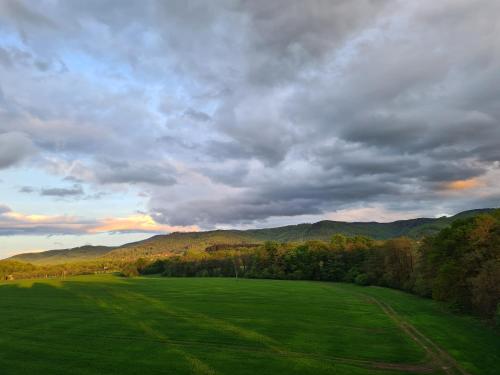 a large green field with mountains in the background at Złota Widokówka in Jaworze