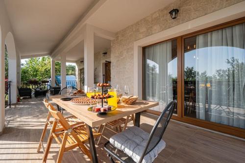a wooden table and chairs on a patio at Active holiday in nature on agritourism! Make wine or olive oil!!! in Posedarje