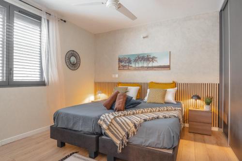 een slaapkamer met een bed en een klok aan de muur bij Exceptionnel ! Appart luxueux à 8 min à pied du lagon in La Saline les Bains