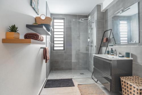W łazience znajduje się umywalka i prysznic. w obiekcie Exceptionnel ! Appart luxueux à 8 min à pied du lagon w mieście La Saline les Bains