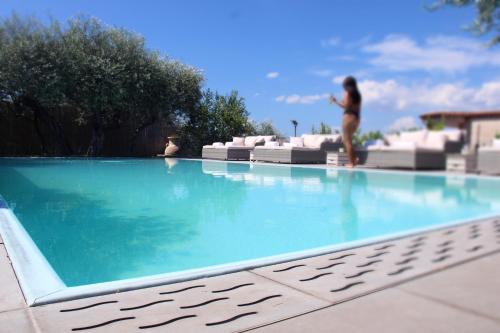 a woman in a bikini standing in a swimming pool at Villa C Luxury Estate in SantʼAntonio Abate