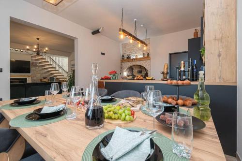 a wooden table with wine glasses and fruit on it at Active holiday in nature on agritourism! Make wine or olive oil!!! in Posedarje