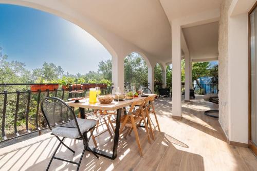 a patio with a table and chairs on a balcony at Active holiday in nature on agritourism! Make wine or olive oil!!! in Posedarje