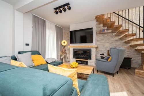 a living room with a blue couch and a fireplace at Active holiday in nature on agritourism! Make wine or olive oil!!! in Posedarje