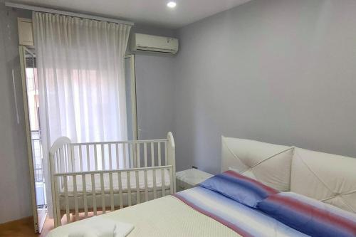 een slaapkamer met een wieg en een babybedje bij Elegant house in Pietraperzia